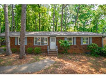Charming brick home with a well-maintained lawn and mature trees at 1671 Drayton Woods Dr, Tucker, GA 30084
