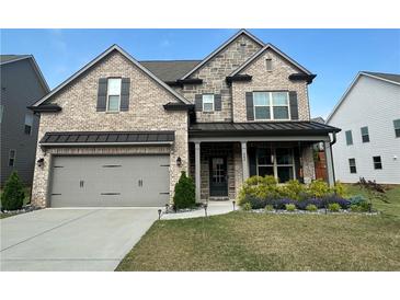 Charming two-story brick home with a well-manicured lawn and a two-car garage at 442 Snow Owl Way, Lawrenceville, GA 30044