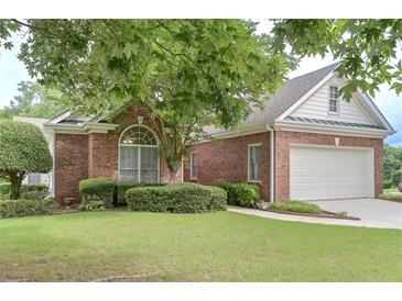 Charming brick home featuring a well-manicured lawn and attached two car garage in a desirable community at 1239 Brentwood Ct, Douglasville, GA 30135