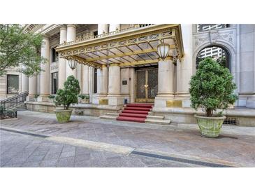 Grand building entrance featuring stately columns, intricate metalwork, and manicured greenery at 75 Ponce De Leon Ne Ave # 403, Atlanta, GA 30308