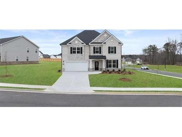 Charming two-story home featuring a brick facade, attached garage, and well-manicured lawn at 1179 Blue Juniper Cir, Loganville, GA 30052