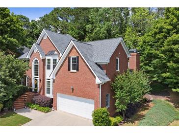 Traditional two-story brick home featuring manicured landscaping and an attached two-car garage at 220 Webley Ln, Alpharetta, GA 30022