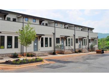 Modern townhouse with neutral exterior, dark trim, small yard, and mountain view in the background at 293 White St # 2, Marietta, GA 30060