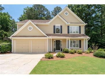 Charming two-story home featuring a well-manicured lawn and an attached two-car garage at 516 Huntgate Rd, Woodstock, GA 30189