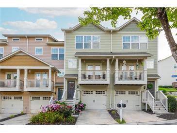 Charming townhome exterior with a two-car garage, beautiful landscaping, and inviting front porch at 1304 Liberty Nw Pkwy # 1610, Atlanta, GA 30318