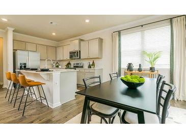 Open kitchen and dining area featuring stainless steel appliances, counter seating, and natural light at 4936 Jatoba Rd, Acworth, GA 30101