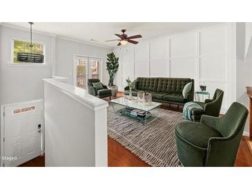 Living room with hardwood floors, green furniture, modern fixtures, and lots of natural light at 1168 Liberty Nw Pkwy, Atlanta, GA 30318