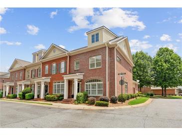 Charming brick townhome with manicured landscaping, arched windows, and inviting front entrance at 5029 Rosalie Rd, Johns Creek, GA 30022