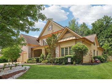 Charming two-story home with lush landscaping, brick accents, and attached two car garage at 895 Mill Garden Pl, Cumming, GA 30040