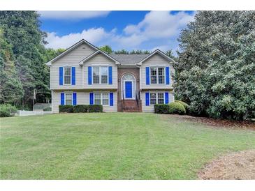 Charming two-story home featuring blue shutters and a well-manicured lawn at 1818 Mcconnell Rd, Grayson, GA 30017