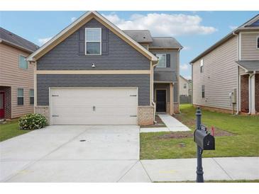 Charming two-story home with a two car garage, landscaped front yard and craftsman style accents at 2493 Oakleaf Rdg, Lithonia, GA 30058