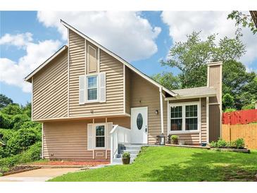 Charming split-level home featuring a unique roofline, neutral siding, and well-maintained landscaping at 1126 Mainstreet Valley Dr, Stone Mountain, GA 30088