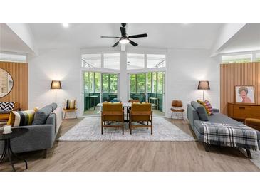 Bright living room features modern furnishings, gray couches, ceiling fan, and outdoor patio view at 2349 Echo Cliff Ne Ct, Atlanta, GA 30345