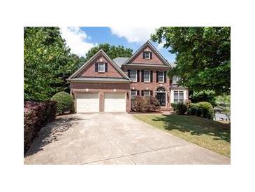 Charming two-story brick home with a two-car garage and well-manicured landscaping at 302 Shawnee Indian Ln, Suwanee, GA 30024