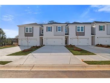 New townhomes with white exteriors, gray accents, and individual driveways under a bright sky at 332 Heavenly Hollow Pl, Mcdonough, GA 30253