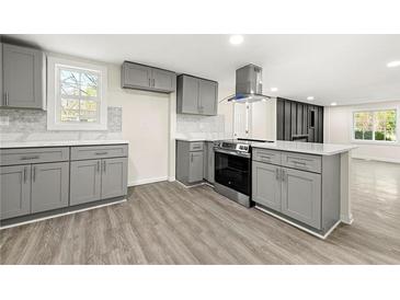 Modern kitchen with gray cabinetry, stainless steel appliances, island, and stylish countertops at 2331 Luther St, Lithonia, GA 30058