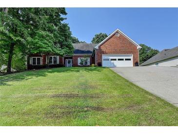 Charming brick home with a well-manicured lawn and attached two-car garage at 1610 Windsong Park Dr, Dacula, GA 30019