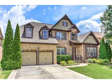 Charming two-story home featuring a stone and brick facade, manicured lawn, and a two-car garage at 4924 Locklear Way, Marietta, GA 30066