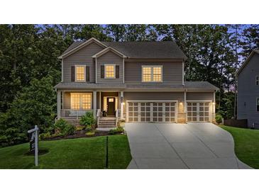 Charming two-story home with a welcoming front porch, well-manicured lawn, and three-car garage at 6045 Stargazer Way, Cumming, GA 30028