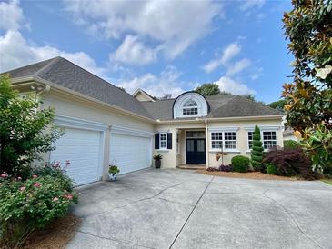 Charming home with a two-car garage, beautifully landscaped front yard, and classic architectural details at 9602 Coastal Pointe Dr, Villa Rica, GA 30180