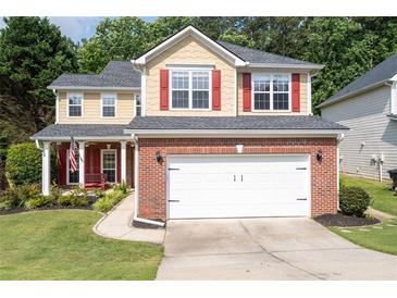 Charming two-story home with brick accents, red shutters, an American flag, a well-manicured lawn and an attached two-car garage at 3362 Palm Nw Cir, Kennesaw, GA 30144
