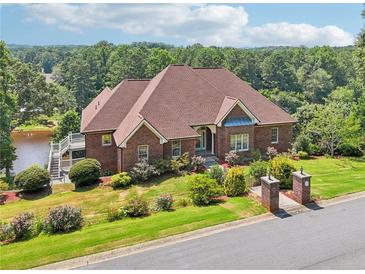 Lovely brick house featuring an attractive red roof, well-manicured lawn, and lakeside access at 55 Rocky Ne Cir, White, GA 30184
