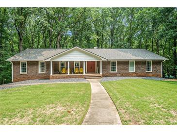 Ranch style home with red brick, white columns, walkway, and a well-manicured lawn at 1310 Chilton Woods Rd, Rutledge, GA 30663