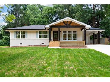 Charming single-story home boasting a spacious front yard with mature trees and a welcoming front porch at 3590 Lee Se St, Smyrna, GA 30080