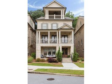Charming three-story home with a double stacked covered porch, a brick facade, and manicured landscaping at 2110 Timball Nw Rd, Atlanta, GA 30318