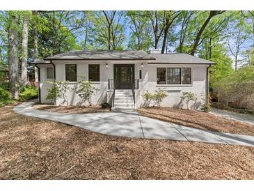 Charming painted brick home with mature trees, landscaping, and inviting front entrance at 3915 Ivy Ne Rd, Atlanta, GA 30342