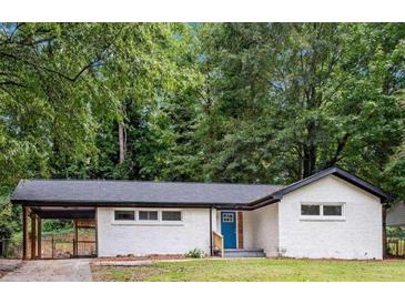 Charming single-story home with a white brick facade, a carport, and a blue front door at 2991 Catalina Dr, Decatur, GA 30032