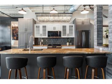 Modern kitchen with quartz countertops, stainless steel appliances, gray cabinets, and stylish pendant lighting at 878 Peachtree St # 601, Atlanta, GA 30309