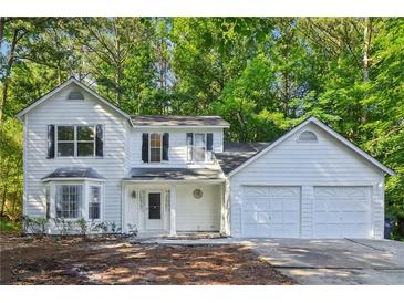 Charming two-story home featuring a two-car garage, bay window, and well-manicured front yard at 310 Wolf Downs Way, Atlanta, GA 30349