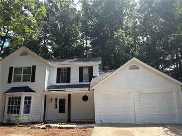 Charming two-story home with a two-car garage and mature trees, all in a desirable neighborhood at 310 Wolf Downs Way, Atlanta, GA 30349