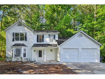Charming two-story home with a two car garage and bay window, nestled in a lush green environment at 310 Wolf Downs Way, Atlanta, GA 30349