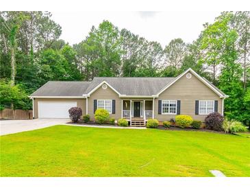Charming single-story home features a well-manicured lawn and attached two car garage at 2430 Tribble Creek Cv, Grayson, GA 30017
