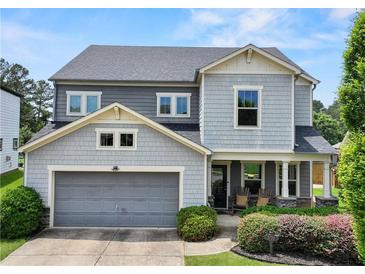 Charming two-story home with a two-car garage, inviting front porch, and landscaped yard at 5730 Arbor Green Cir, Sugar Hill, GA 30518