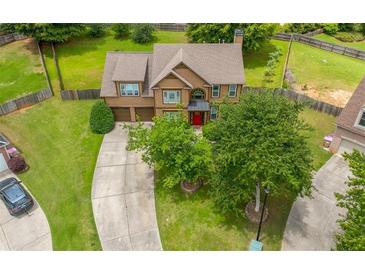 Charming two-story home with a well-maintained front yard, long driveway, and inviting red front door at 2870 Tattersall Ct, Cumming, GA 30041