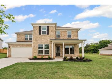 Charming two-story brick home with a well-manicured lawn and covered front porch at 120 Aj Welch Jr Way, Mcdonough, GA 30252