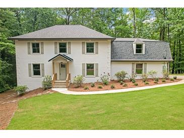 Charming home featuring a well-manicured lawn and lush landscaping, complete with shuttered windows at 4800 Timberland Sw Dr, Mableton, GA 30126