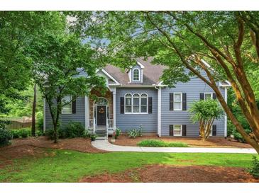 Charming home featuring stone accents, gray siding, lush landscaping and a welcoming front porch at 2045 Bethany Spring Trce, Cumming, GA 30041