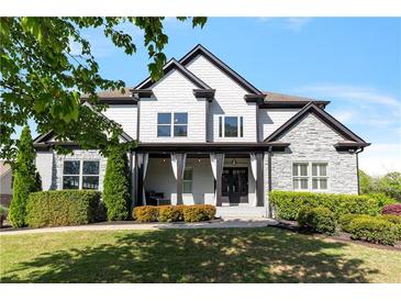 Charming two-story home featuring a stone and white shingle facade, manicured lawn, and inviting covered porch at 1186 Lincoln Dr, Marietta, GA 30066