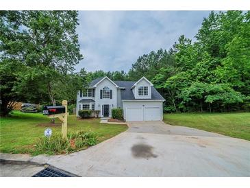 Charming two-story home features a two-car garage and a well-manicured front yard at 621 Lakewater View Dr, Stone Mountain, GA 30087