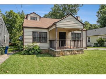 Charming bungalow with a cozy front porch, stone accents, and a well-manicured lawn at 821 Erin Sw Ave, Atlanta, GA 30310
