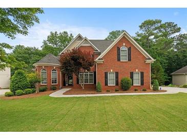 Charming brick two-story home featuring well-manicured lawn and a welcoming front entrance at 1012 Chestnut Creek Dr, Villa Rica, GA 30180