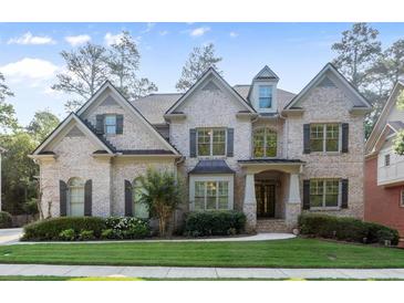 Charming two-story brick home with manicured lawn and lush landscaping at 10565 Highgate Manor Ct, Duluth, GA 30097