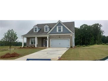 Charming two-story home with a gray brick facade, dormer windows, two-car garage and well-manicured lawn at 5985 Spring Way, Stonecrest, GA 30038