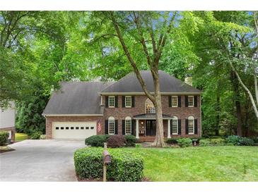Charming brick home with mature trees, manicured lawn, and a two-car garage at 4246 N Mountain Ne Rd, Marietta, GA 30066