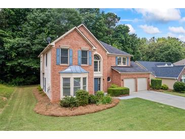 Charming brick home with a well-manicured lawn and a two-car garage at 3652 Morning Creek Ct, Suwanee, GA 30024