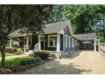 Charming home with a covered front porch, gravel driveway and lush landscaping creates a welcoming curb appeal at 583 Etowah Ne Dr, Marietta, GA 30060